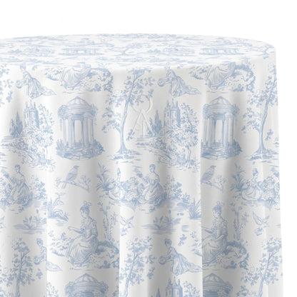A round tablecloth with a classic blue and white toile de Jouy pattern featuring classical figures, trees, and architectural details, shown draped over a table against a white background.