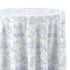 A round tablecloth with a classic blue and white toile de Jouy pattern featuring classical figures, trees, and architectural details, shown draped over a table against a white background.