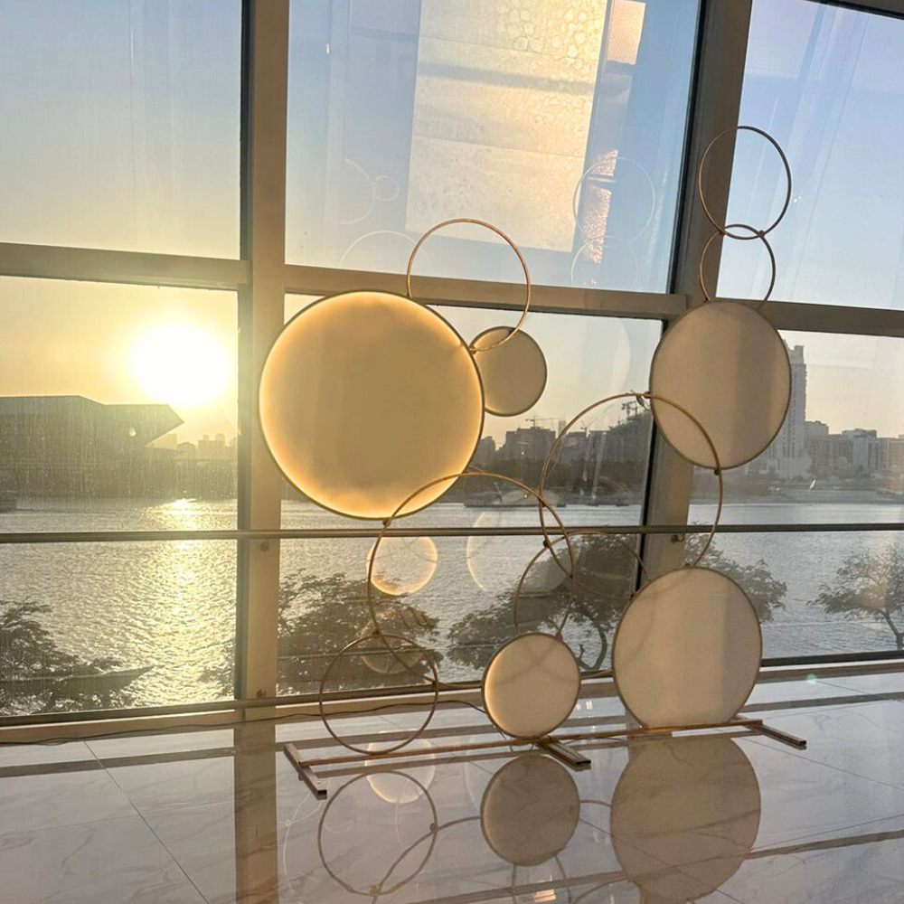 CircleScape LED Backdrop, a circular metal structure ideal for event settings like weddings or baby showers, positioned against a large window.
