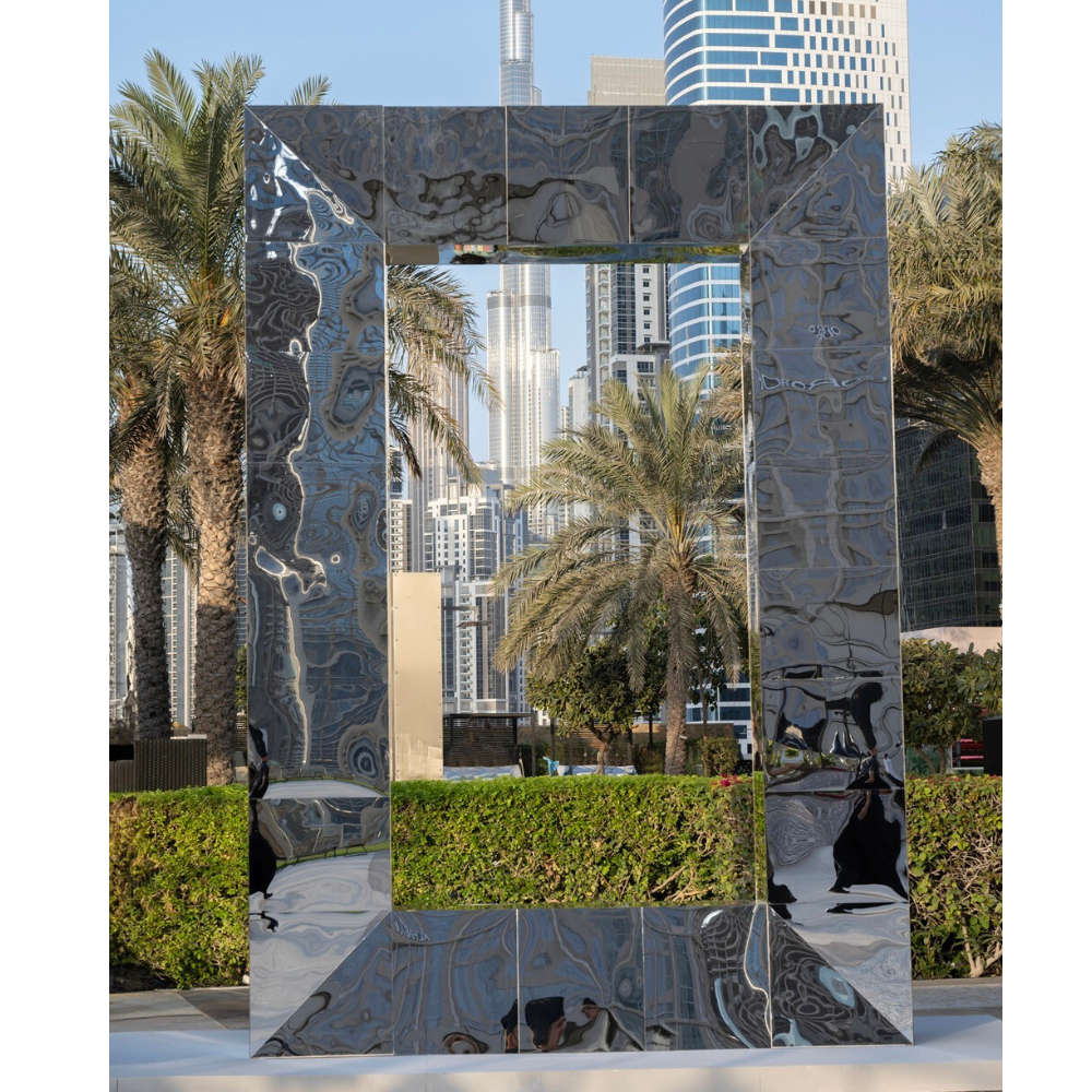 Silver Mirror Frame with sleek metallic finish, perfect for event décor, reflecting cityscape and palm trees, available for rent from Party Social.