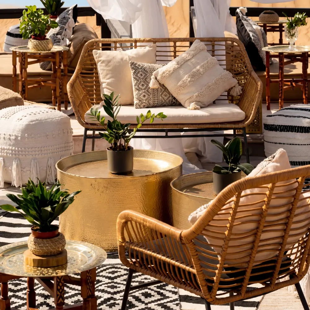 RATTAN 2-SEATER amidst a cozy boho lounge, featuring textured pillows and matching wicker chairs, perfect for elegant outdoor events by Party Social.