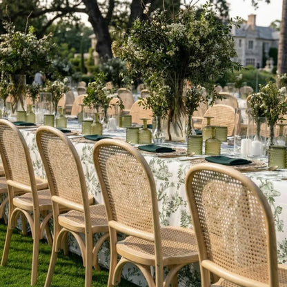 RATTAN CHAIRS elegantly surround a banquet table, enhancing a garden-party setting with their classic European bistro style and airy textures. Ideal for sophisticated events.