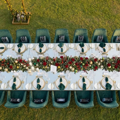 VELVET CHAIR ROYAL GREEN encircles a festive outdoor dining table adorned with elegant tableware and garland, highlighting Party Social&
