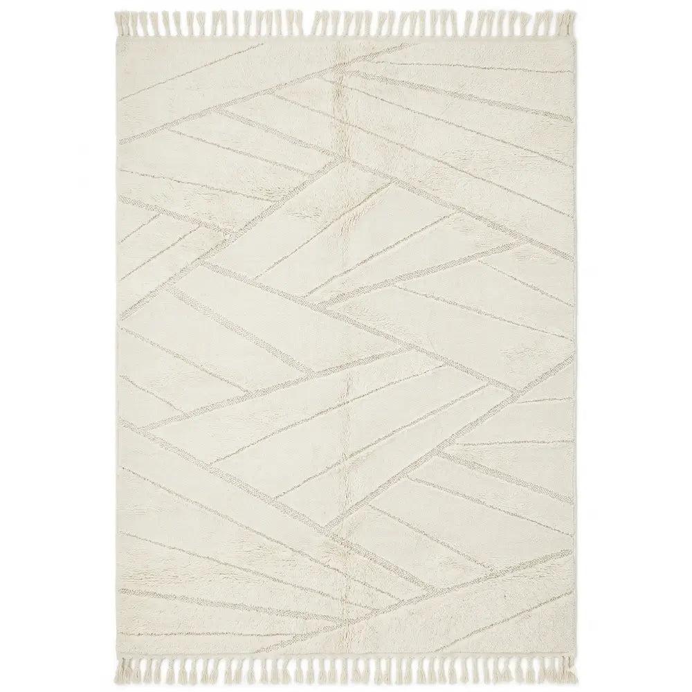 RUG ABSTRACT NATURAL WOVEN: Rectangular area rug with a subtle geometric pattern and tassel fringe, ideal for adding warmth and texture to event spaces.