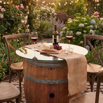 Rustic Wine Barrel Table 225ltr with glass top, set for outdoor dining with wine, cheese, and votives, surrounded by wooden chairs in a garden setting.