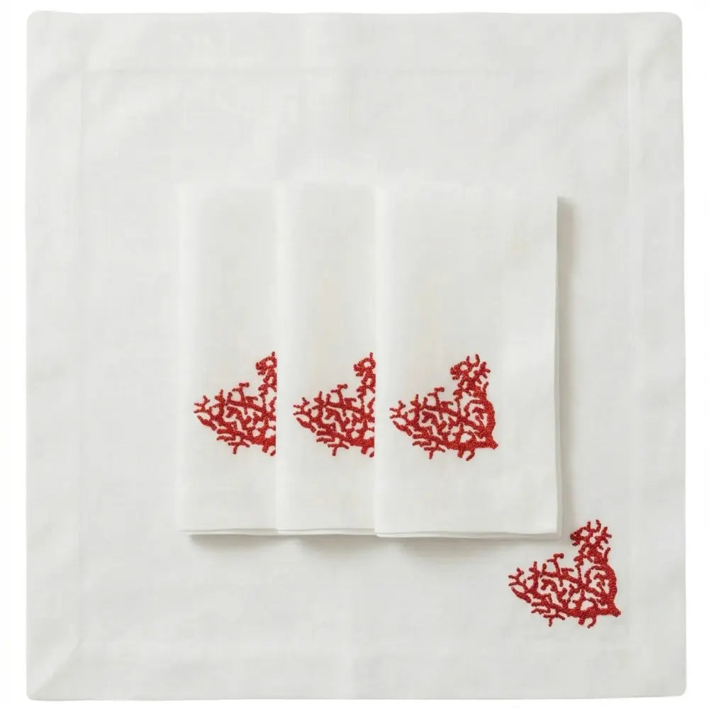 Set of four Red Coral Pure Linen Dinner Napkins, neatly folded with red coral-branch embroidery on white linen, ideal for coastal-themed events and elegant gatherings.