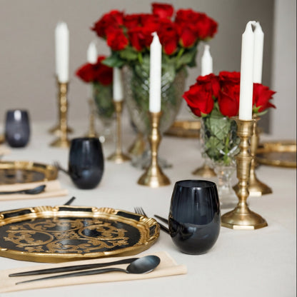 The Midnight Majlis Collection: Elegant dining setup with black-and-gold charger, black flatware, tinted tumbler, and brass candlesticks, perfect for sophisticated Ramadan gatherings.