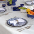 Qamar Bleu - Dinner Setup featuring blue-and-white plates, silverware, crystal glasses, and napkin on a formally set table for an elegant event.