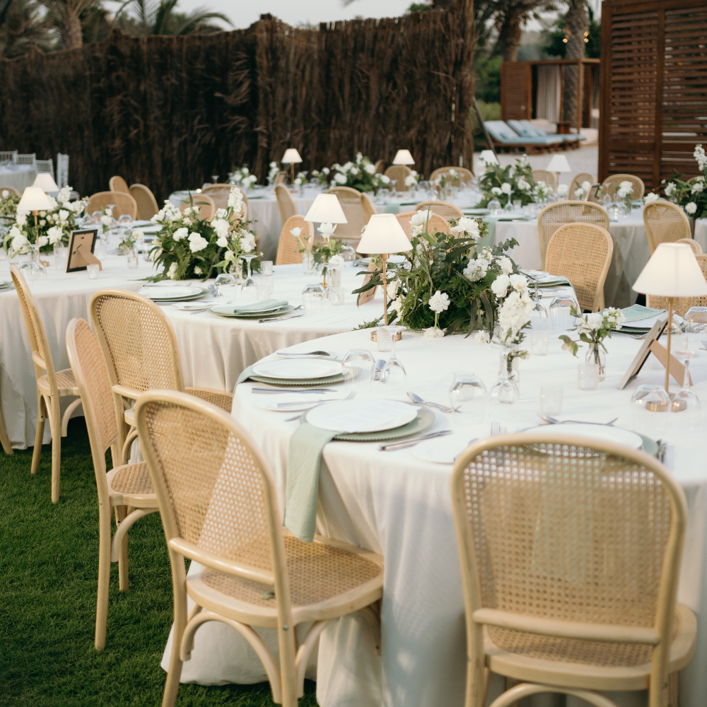 Round Banquet Tables set outdoors with white linens and floral centerpieces, ideal for elegant gatherings, comfortably seating 6-8 people in a garden-party vibe.