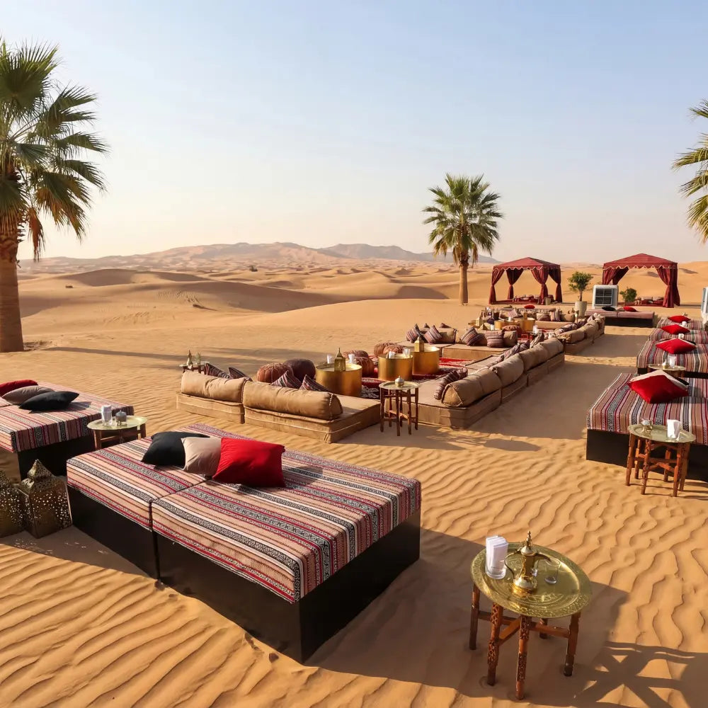 Sofa Island in a desert camp setting, featuring patterned fabrics, oversized cushions, and small brass tables for a luxurious lounge experience.