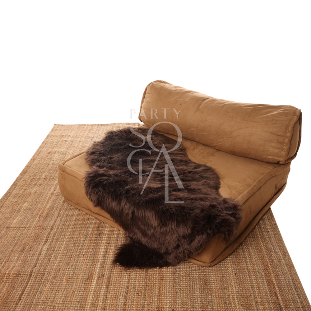 Sheepskin Curved on a brown couch, ideal for decor or event props, featured with a fur texture and suitable dimensions for versatile styling.