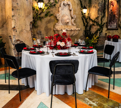 Simple Velvet Chairs with gold and black legs, ideal for elegant dinner parties and events, shown around a table set with stylish tableware.