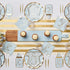 Overhead view of a baby shower table with gold-edged, onesie-shaped Hey Baby! plates, matching napkins, and Everyday Sky Blue Paper Dinner Plates.