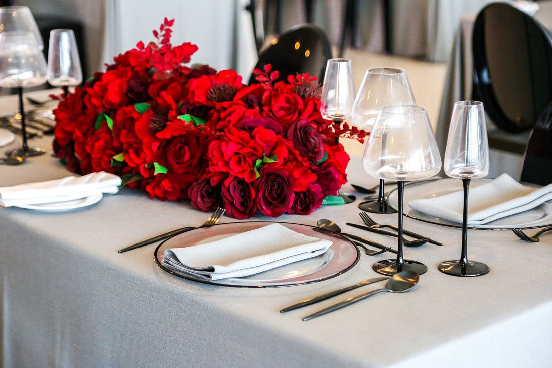 Black Stemmed Glasses elegantly arranged on a dining table with red flowers and silverware, enhancing the luxurious ambiance for special occasions.