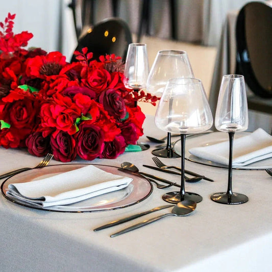 Black Stemmed Glasses elegantly arranged on a dining table with red flowers and silverware, enhancing the luxurious ambiance for special occasions.
