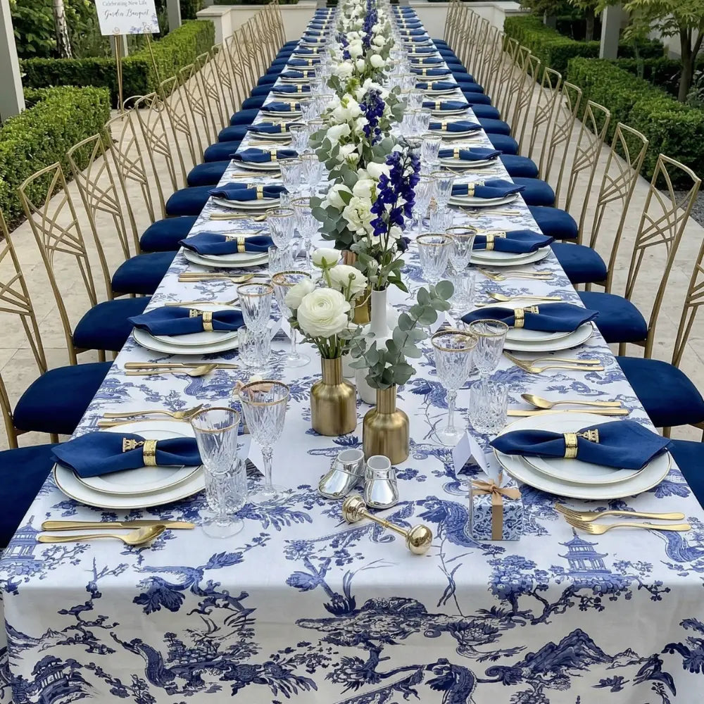 TOILE DE JOUY PRINT RECTANGULAR TABLECLOTH elegantly drapes a long dining table, complemented by uniform place settings and floral arrangements, perfect for formal gatherings.