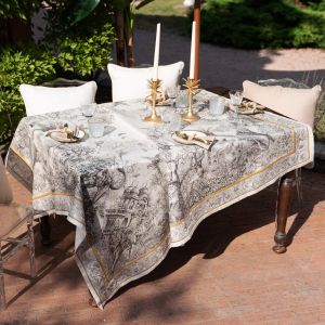 Elegant toile tablecloth and gold candle holder setup for luxury event styling