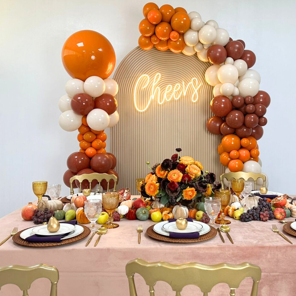 Autumn Balloon Backdrop featuring orange and white balloons, a golden apple, and flowers, ideal for Thanksgiving parties. Personalization and LED Neon Sign options available.