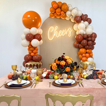 Autumn Balloon Backdrop featuring orange and white balloons, a golden apple, and flowers, ideal for Thanksgiving parties. Personalization and LED Neon Sign options available.