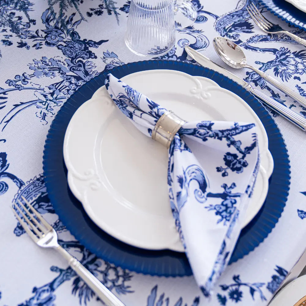 Table setting with blue and white floral patterns on a tablecloth.
