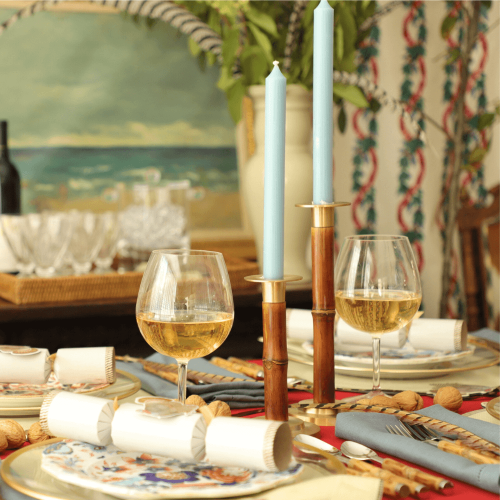 Two elegant 10” Duet Crown Candles on a table with wine glasses. Paraffin and palm wax blend with lead-free cotton wick for clean, dripless burn. Perfect for adding warmth to any Caspari table setting.