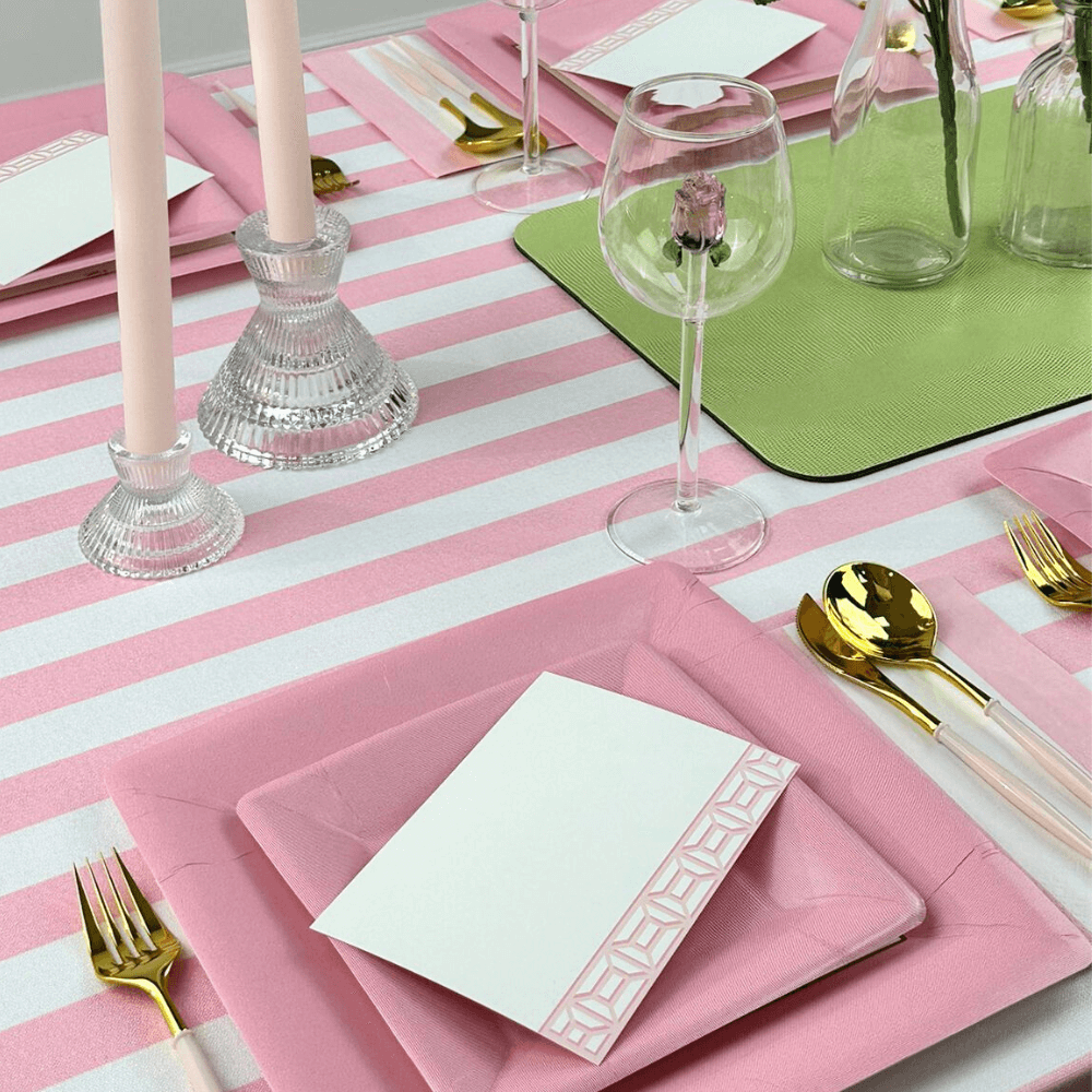 Pink Stripe Linen Tablecloth on a table, adorned with pink and green plates, glasses, and silverware, showcasing elegant tableware for special occasions.