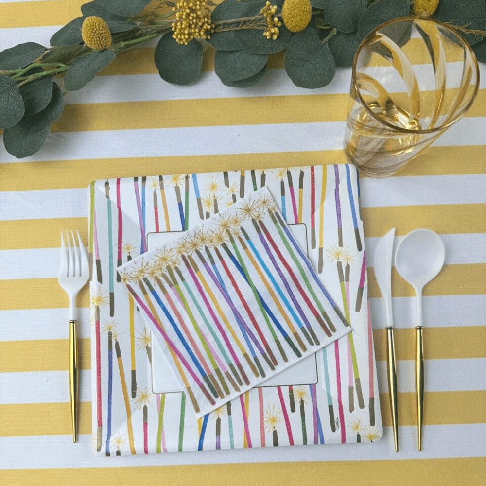 A table set with Party Candles Paper Luncheon Napkins, forks, and a glass of water. Eco-friendly, triple-ply napkins with artistic designs, FSC-certified and compostable. Perfect for parties and events.