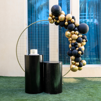 Black &amp; Gold Backdrop featuring a striking balloon arch, ideal for enhancing party settings with a customizable theme, available from Party Social.