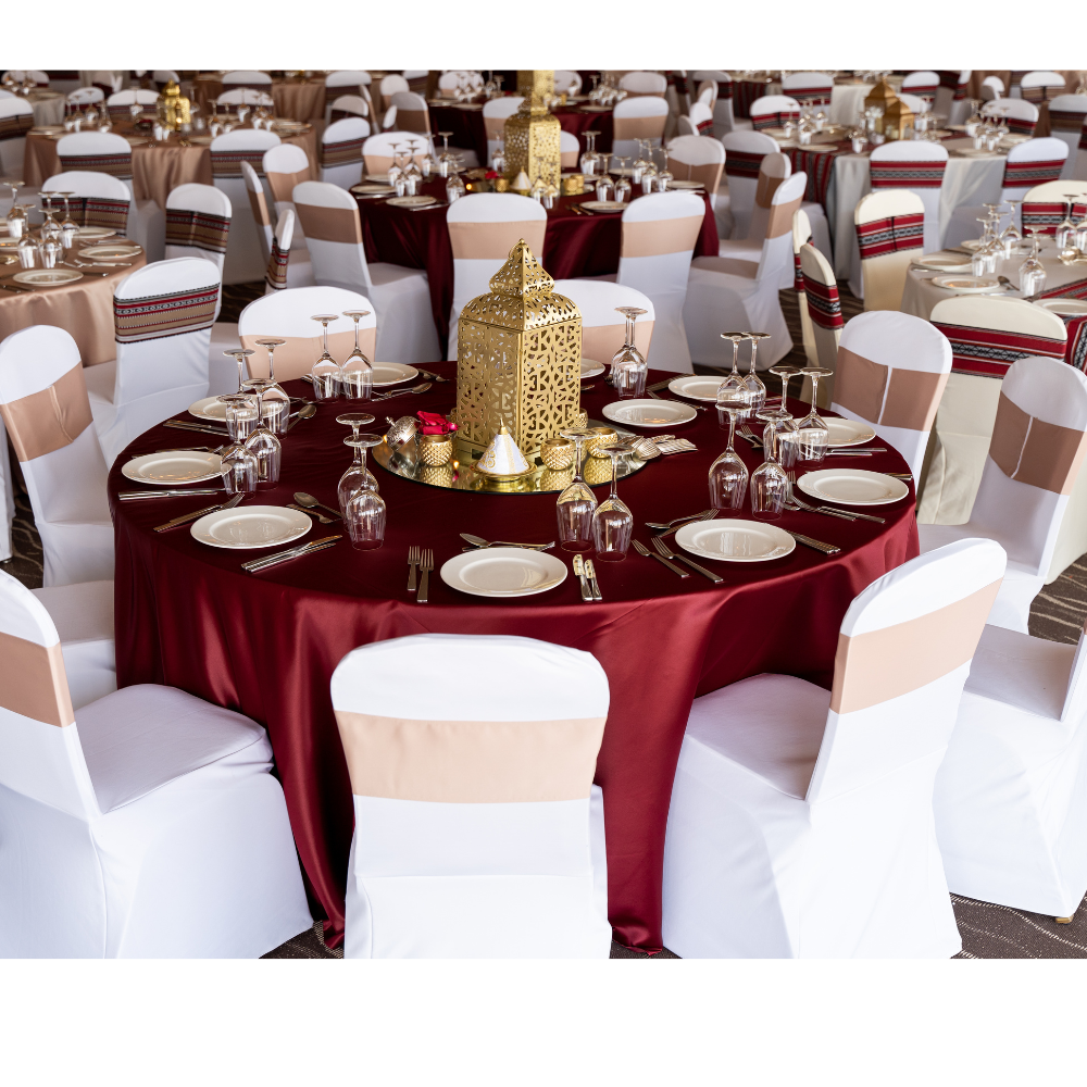 Round satin tablecloth draped elegantly over a banquet table set for a dinner party, showcasing premium tableware and decor accents.