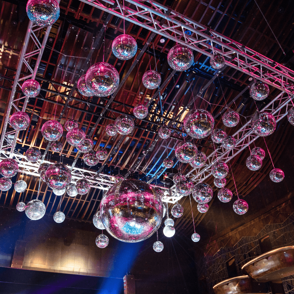 Disco Balls hanging from the ceiling, perfect for adding unique style to events. Available in various sizes, ideal for parties and special occasions.