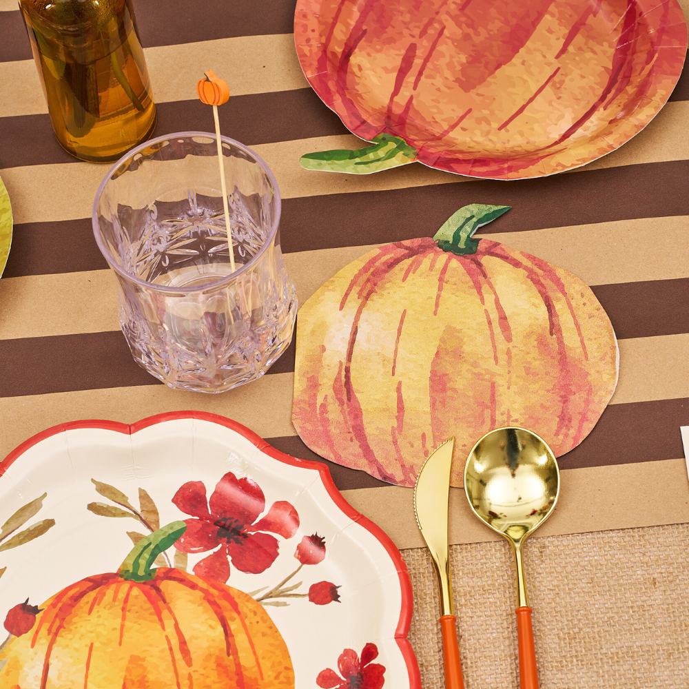 Autumn Foliage Pumpkin Luncheon Napkins on a table set with matching paper tableware, perfect for enhancing party decor.