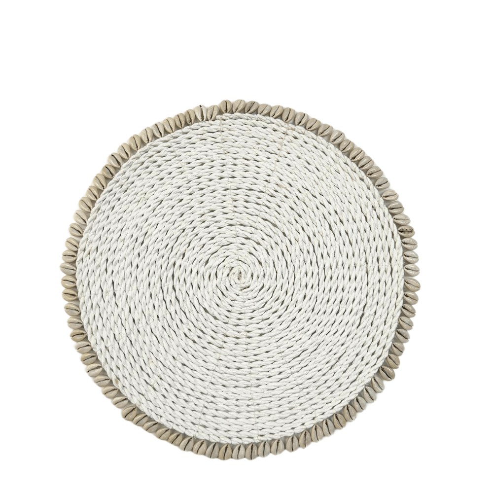 A round seagrass placemat with white seashells, woven intricately for a chic table setting. Durable, eco-friendly, and stylish for any meal. From Party Social&