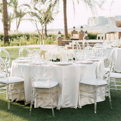 Round Velvet Tablecloth displayed on an elegantly arranged outdoor wedding table, featuring clear plastic chairs with white cushions, ideal for special occasions.