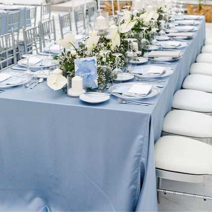 Rectangular satin tablecloth on a long setup with white chairs and floral centerpieces, ideal for weddings or special events. Premium quality for elegant occasions.