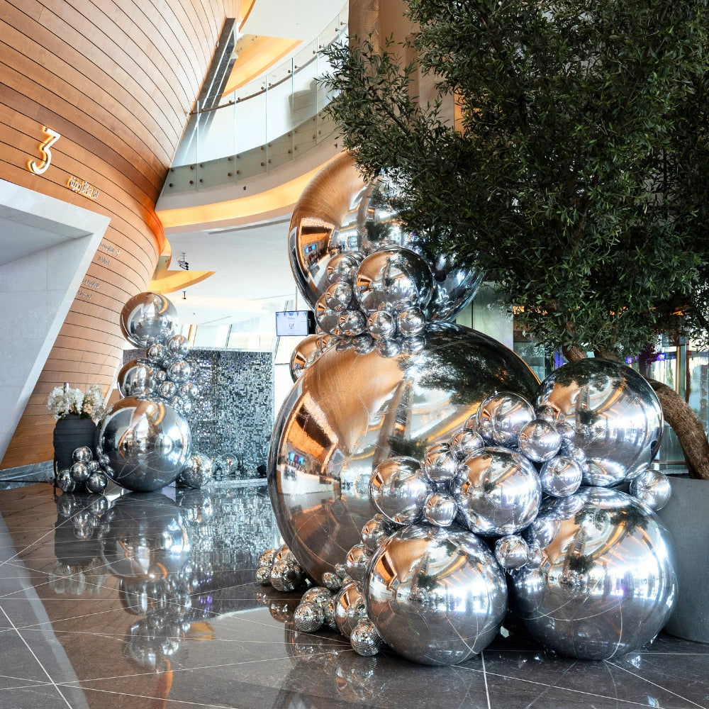 Silver Mirror Inflatable Balls on a marble floor, perfect for event decoration, made from quality PVC, available in various sizes for party enhancements.