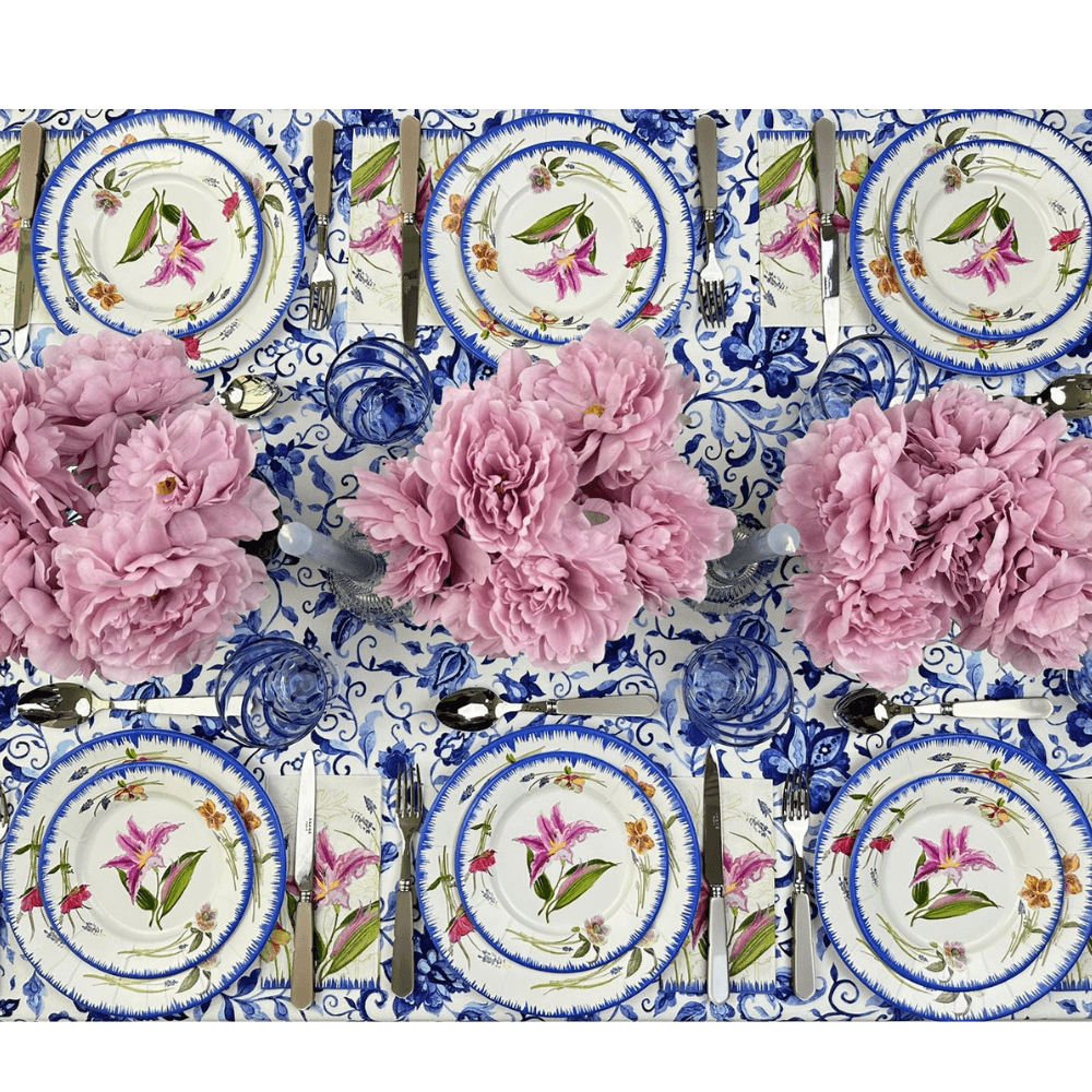 A Summer Florals Polyester Linen Tablecloth from Party Social, featuring pink flowers on plates and silverware. Elevate your table setting with this premium, reusable piece for any event.