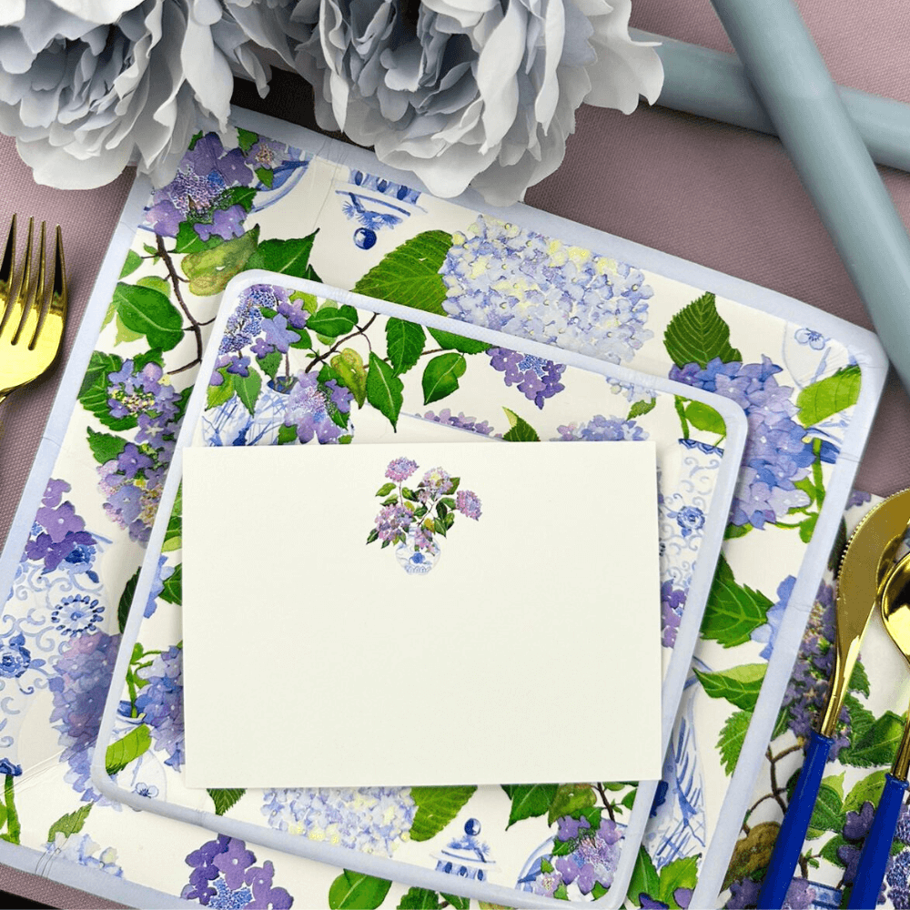 Hydrangeas and Porcelain Blank Correspondence Cards - 20 Per Package displayed on a plate with silverware and floral pattern, ideal for handwritten notes.
