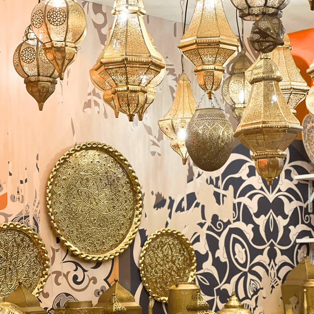 Round Moroccan Hanging Pendant lantern with intricate patterns, designed for candle lighting, showcased among a group of gold lanterns. Ideal for enhancing party atmospheres.