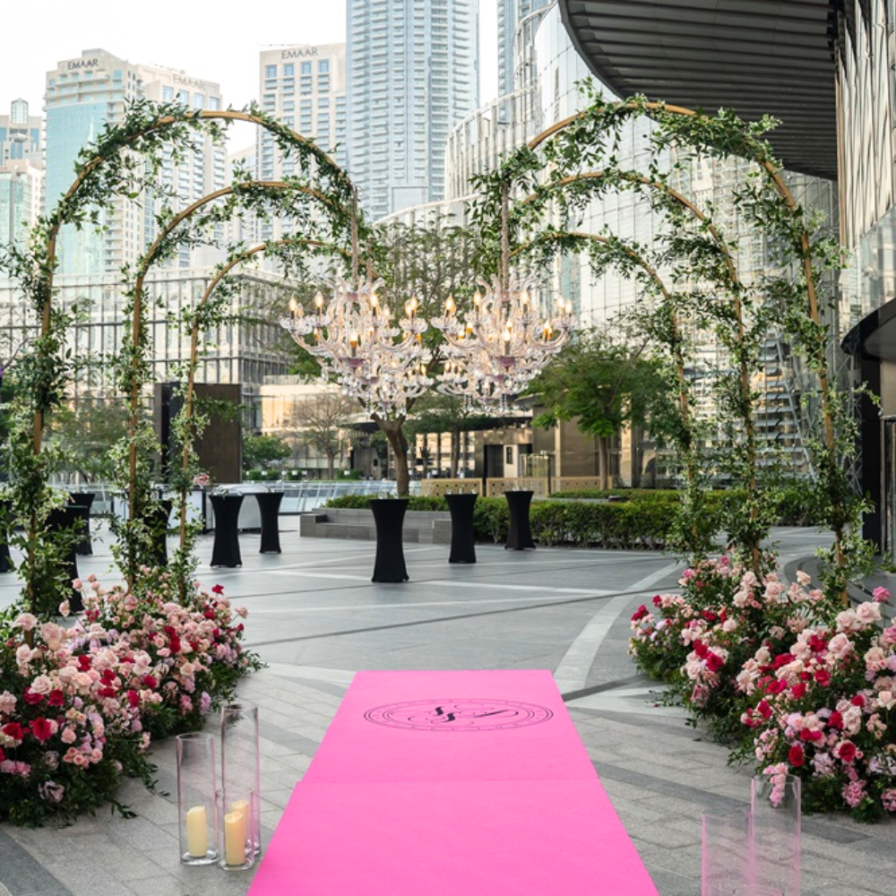 Chandelier Stand displayed outdoors, surrounded by flowers and candles, showcasing its elegant design for creating a sophisticated ambiance at events.