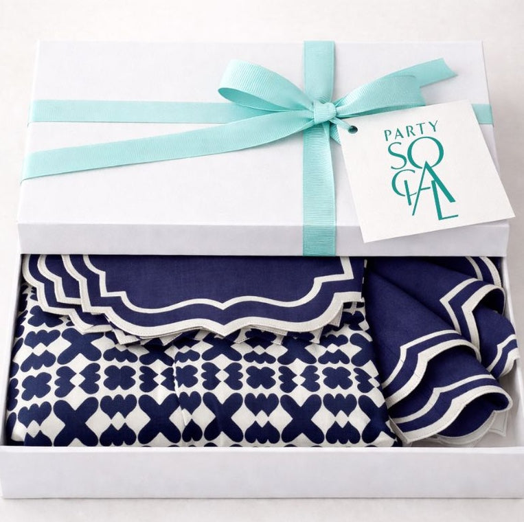 The Iftar Table Edit Gift Box: A white box with aqua ribbon, containing navy-and-white patterned napkins, ideal for Ramadan celebrations or gifting from Party Social.