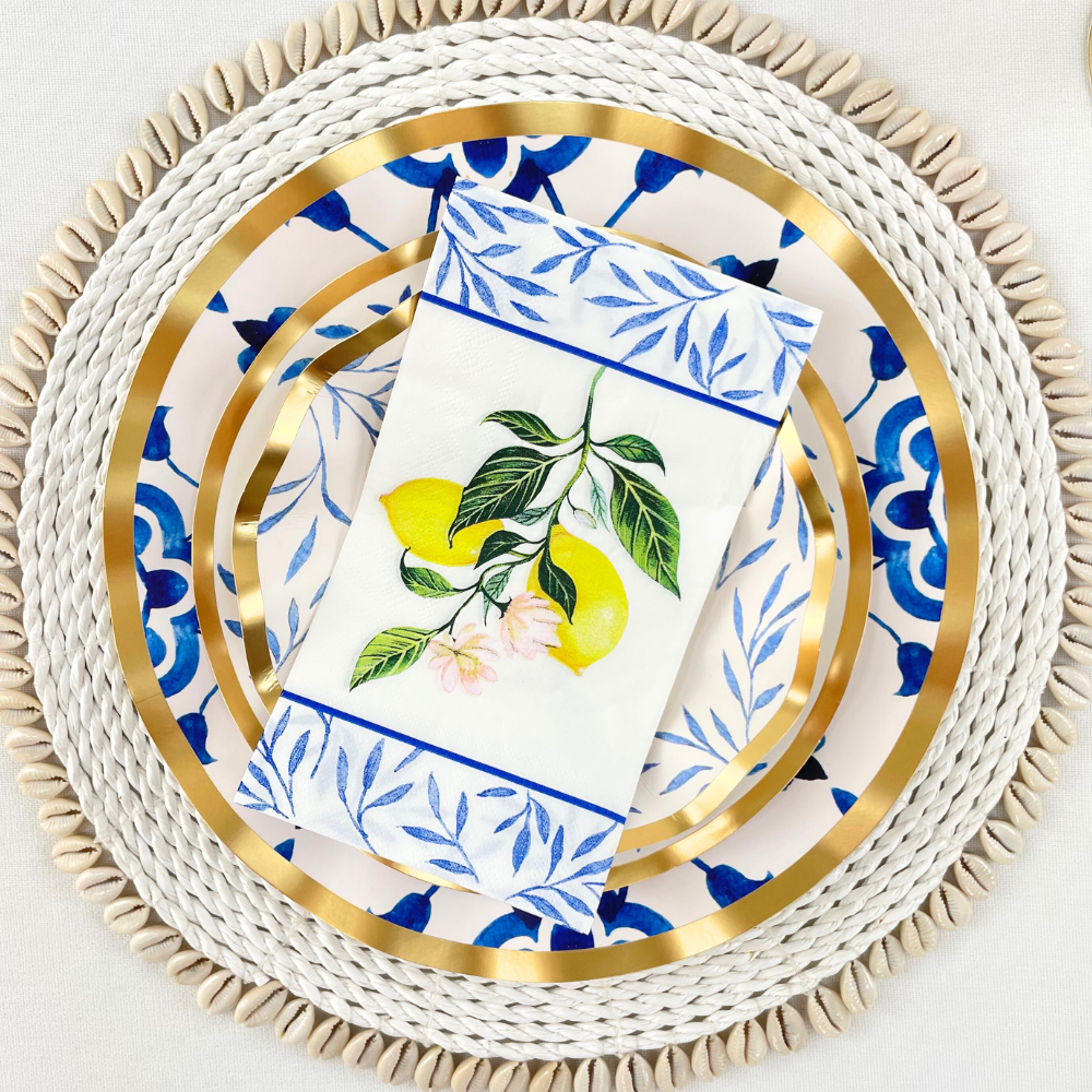 A porcelain platter with Capri Coast paper guest towel napkins featuring a lemon and leaf design. Ideal for elegant dining setups and parties. From Party Social&