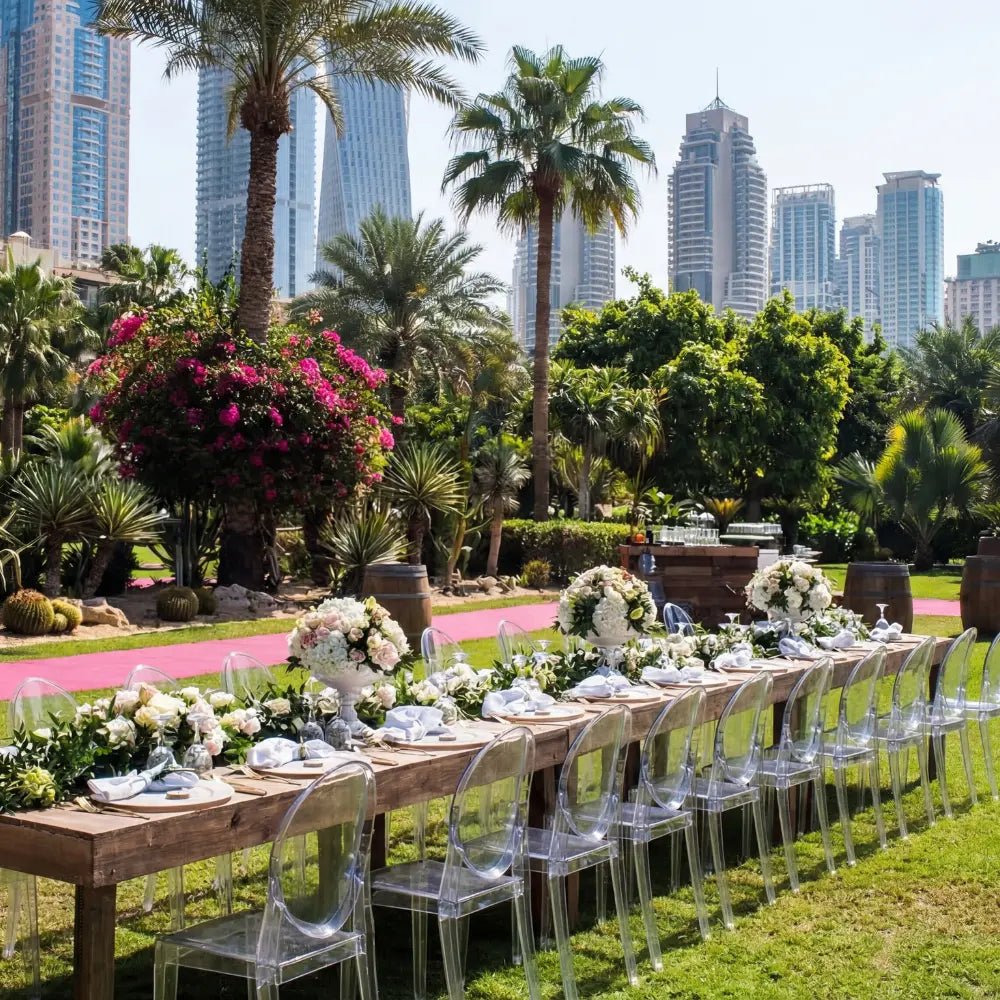 GHOST CHAIR W/O ARMS (VICTORIA) surrounds a rustic banquet table, blending modern design with elegant floral arrangements in an upscale outdoor event setting.