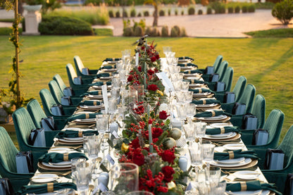 VELVET CHAIR ROYAL GREEN at an elegantly set dinner table with tableware and floral centerpieces, ideal for sophisticated events and parties.