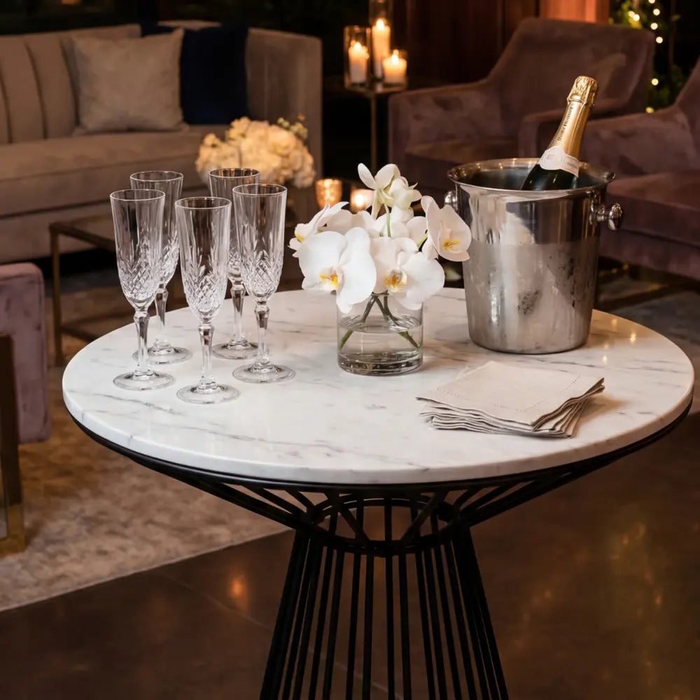BLACK WIRE COCKTAIL TABLE-WHITE MARBLE TOP with champagne flutes, orchids, ice bucket, and napkins, set for an elegant event by Party Social.