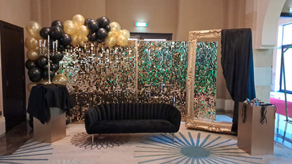 Sequin Wall in square mesh backdrop, perfect for events, enhancing decor with floral or balloon arrangements. Features a couch and mirror in the background.