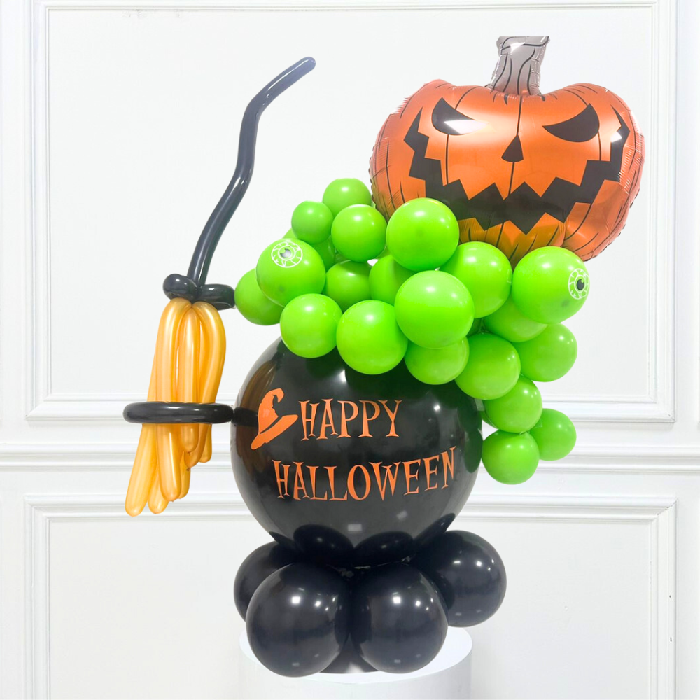 Witch Pot Balloon Stack featuring lime green, black, and pumpkin-shaped balloons with a broom, perfect for Halloween party decor.