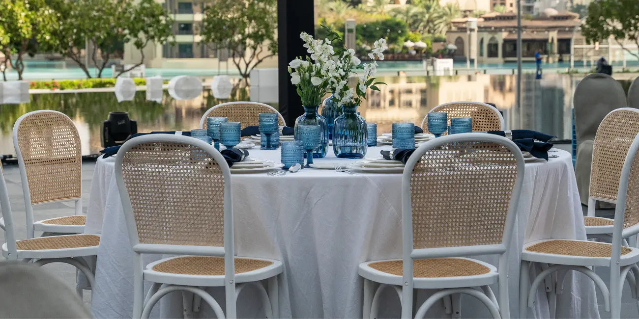 White Rattan Chairs in a round table covered with linen