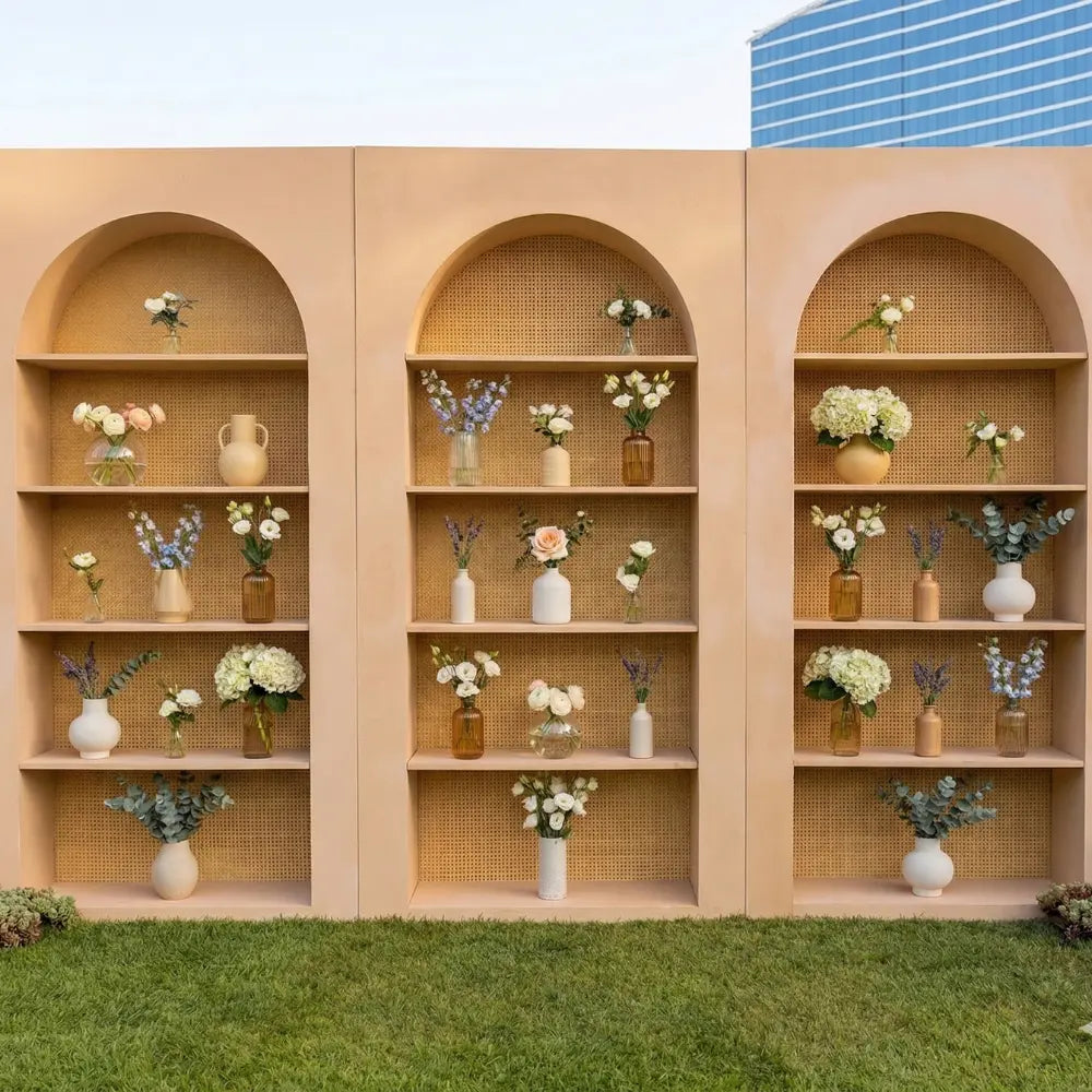 Wooden Rattan Bar Back featuring arched light-wood panels with shelves displaying floral arrangements, ideal for enhancing event décor with a stylish and functional backdrop.