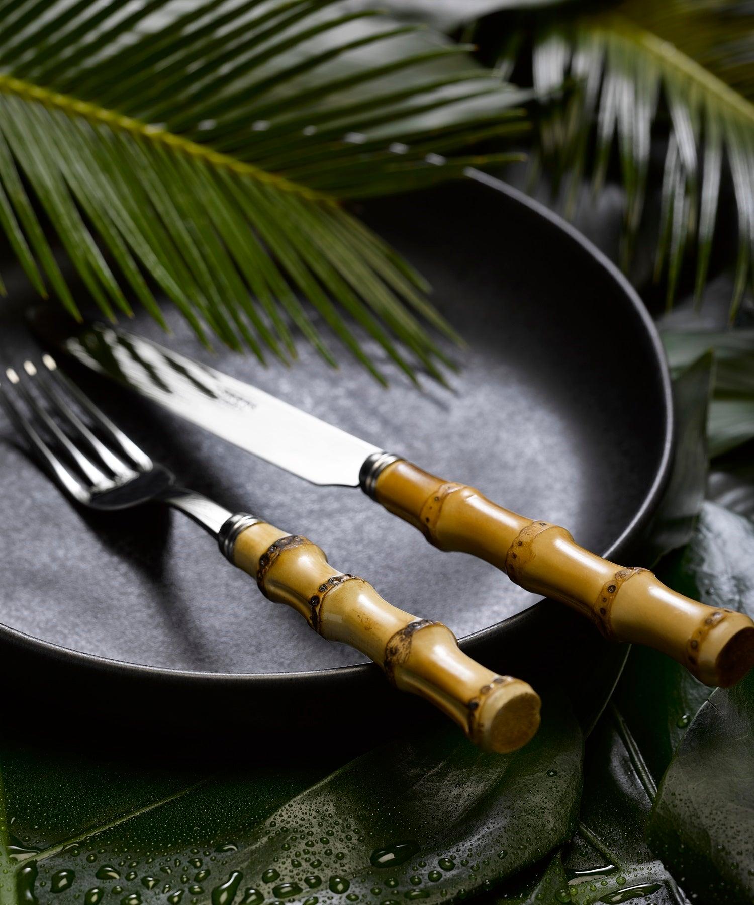 Bamboo Light Cutlery Set of 5: A stylish fork and knife on a plate.