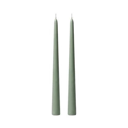 Two slim, pointed taper candles in a muted sage green color, standing upright side-by-side on a plain white background.